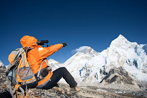 Woman looking through binoculars at Mount Everest