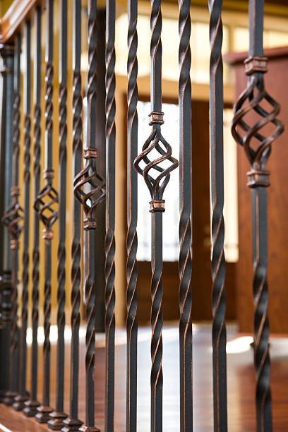 Staircase hand rail and banister detail in home. "Staircase custom hand rail, banister and wrought iron spindle detail in a residential home." baluster stock pictures, royalty-free photos & images