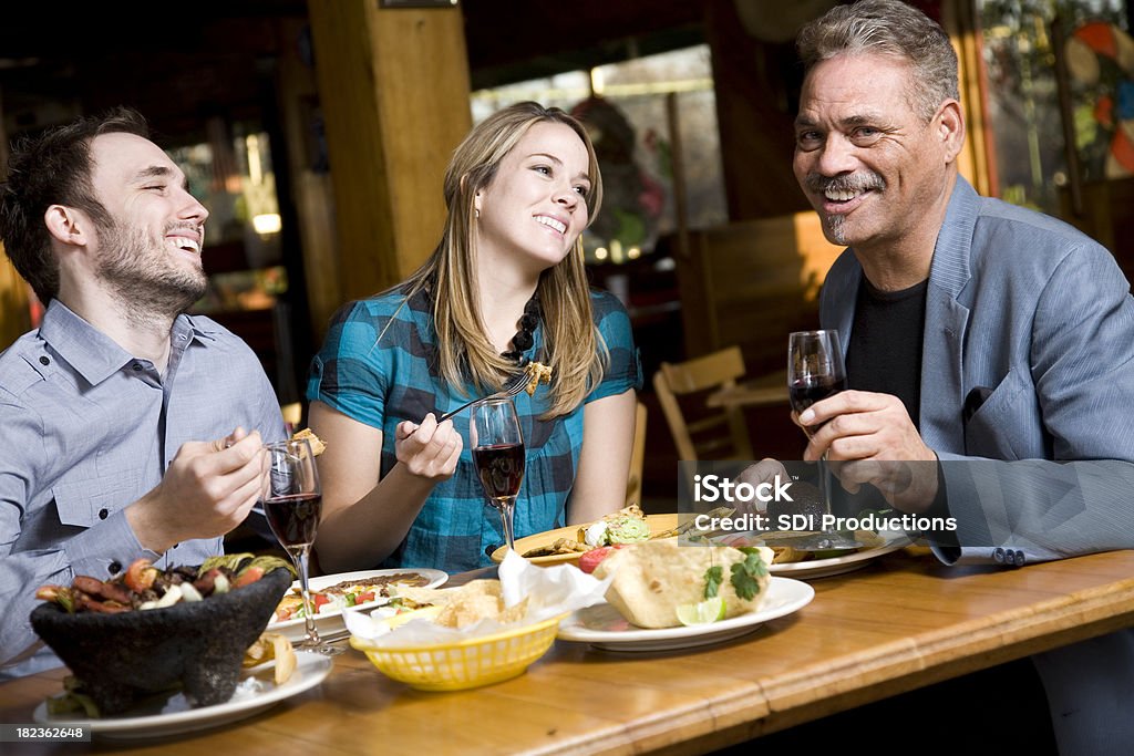 Friends Laughing at Dinner Having Mexican Food Friends Laughing at Dinner Having Mexican Food.See more from this series: Eating Stock Photo