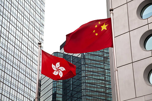 Hong Kong and China flags against commercial buildings