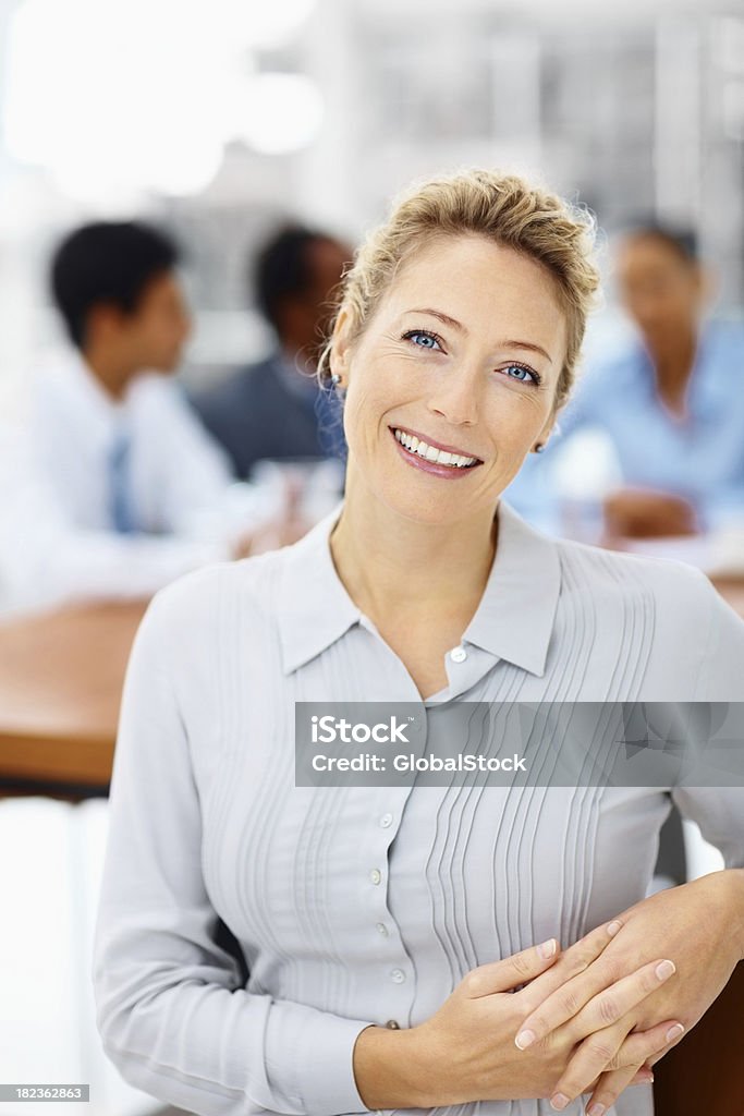 Donna d'affari sorridente felice con i colleghi nella parte posteriore - Foto stock royalty-free di 20-24 anni