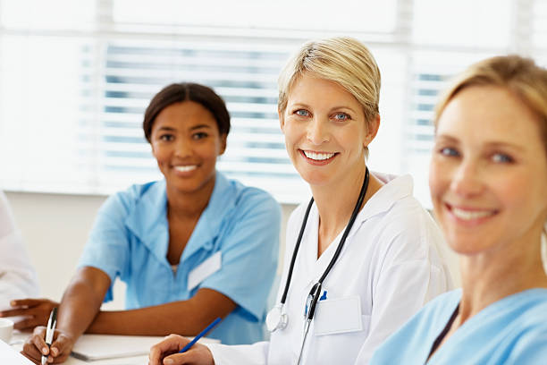 istock Happy female doctor sitting with colleagues 182362997