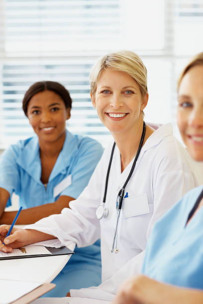 istock Female doctor sitting with colleagues 182363001