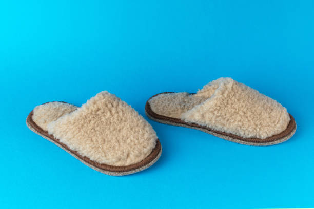 istock Light wool slippers walking on a blue background. 1823630172