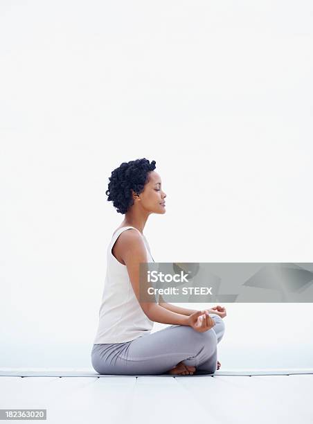 Joven Mujer Sentada En Postura De Loto Foto de stock y más banco de imágenes de Meditar - Meditar, Mujeres, Perfil - Vista de costado