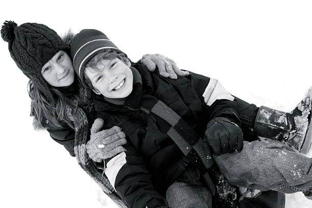 A two-year-old girl stands bundled in a cozy coat and woolly hat, her rosy cheeks glowing in the crisp air as she experiences her first snowfall. Her eyes widen with wonder as the snowflakes gently fall from the sky, dancing around her in soft swirls. A smile slowly spreads across her face, pure joy lighting up her features. She reaches out with mittened hands, trying to catch the delicate flakes as they disappear on contact, giggling at the magic. The soft crunch of snow under her tiny boots adds to her excitement, and in this moment, the world feels enchanted, filled with the wonder of childhood discovery.