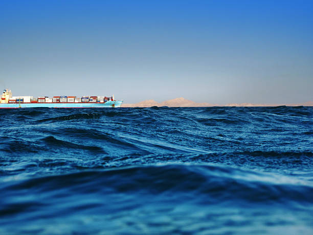 Cargo ship and desert Tiran island on horizon, 