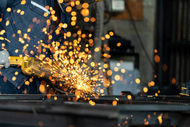 istock Skill metalworker uses a grinder to polish a smooth metal surface. Precision and dedication for industry transforms raw materials into works of art. Sparks that erupt from the grinding process create a captivating spectacle of brilliance. 1823643699