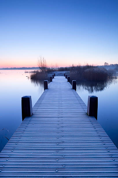 istock Boardwalk on a lake at dawn in winter, The Netherlands 182364735