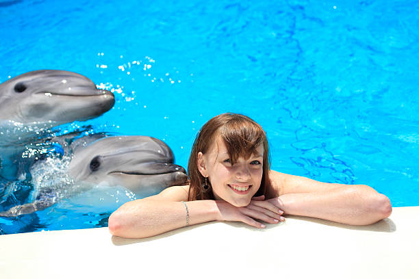 istock woman in a pool with dolphins 182364929