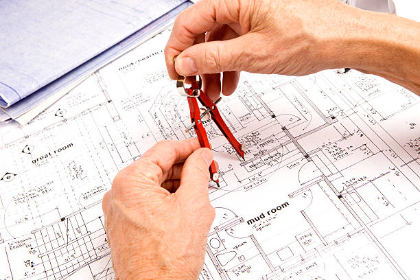 istock Male Hand Drawing Arc on Blueprint with Compass 182365059