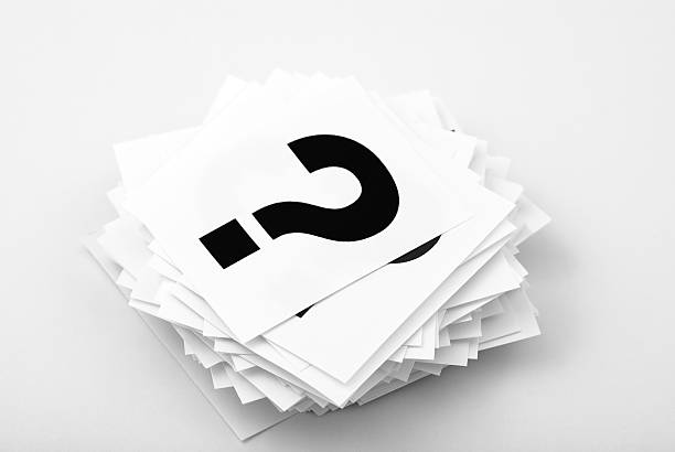 A stack of white cards with black question marks stock photo