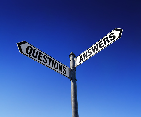 Low-angle view of signpost with two arrows: Questions and Answers.