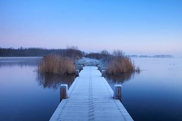 istock Boardwalk on a lake at dawn in winter, The Netherlands 182366303