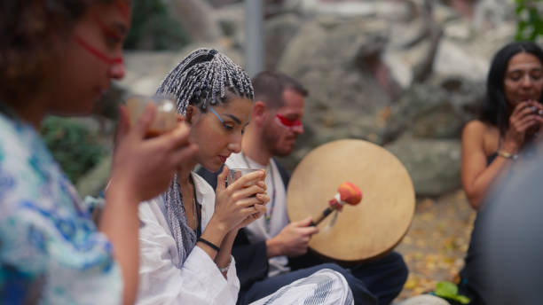 gruppo di amici multietnici che si riuniscono nella natura e hanno una cerimonia di bevanda al tè al cacao - frame drum foto e immagini stock