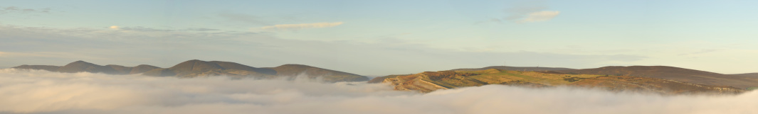 A panoramic shot of the hills above Llangollen emerging from the fog.