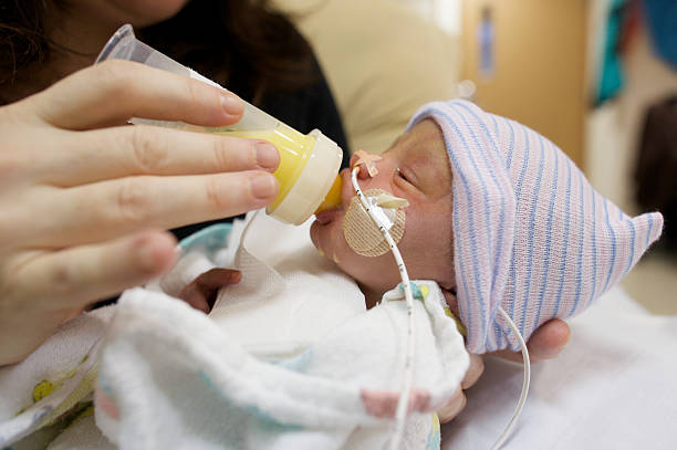 Preemie Feeding A premature baby feeding on breastmilk. breast milk stock pictures, royalty-free photos & images