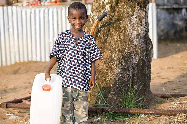 African boy carrying a water jug.