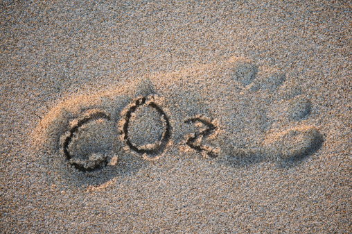 CO2 carbon dioxide message in sunken footprint in textured sand