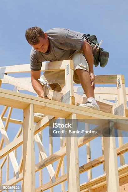 Builder Hammering Tetto Capriate Chiodo Contro Il Cielo Blu - Fotografie stock e altre immagini di Attrezzi da lavoro