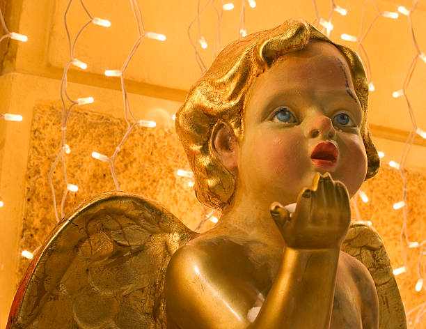 Statue on an angel rising its hand for praise. Open mouth as for singing.