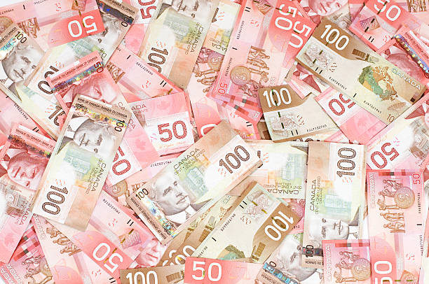 Dollars Canadian money 50 and 100 dollar bills cash flow photos stock pictures, royalty-free photos & images