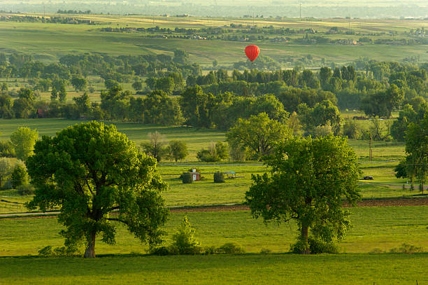A hot air balloon lifts off over farmland outside of Boulder Colorado.