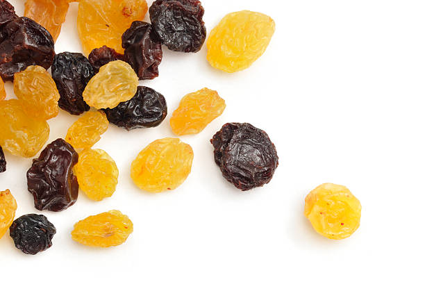 Yellow and Black raisins scattered on a white background.