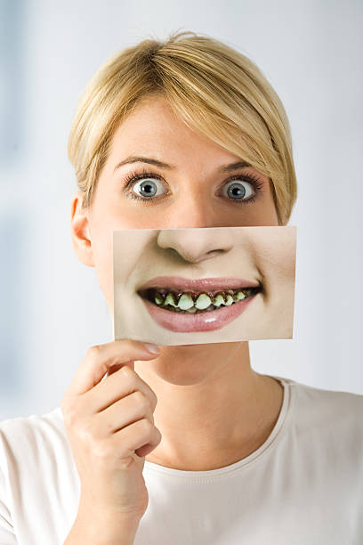 woman with image of rotten teeth Photo that model holding I made specially for this shooting.I am the author and copyright holder of the photo.In this photo is part of the same persons (model) who hold this photo. bad teeth stock pictures, royalty-free photos & images