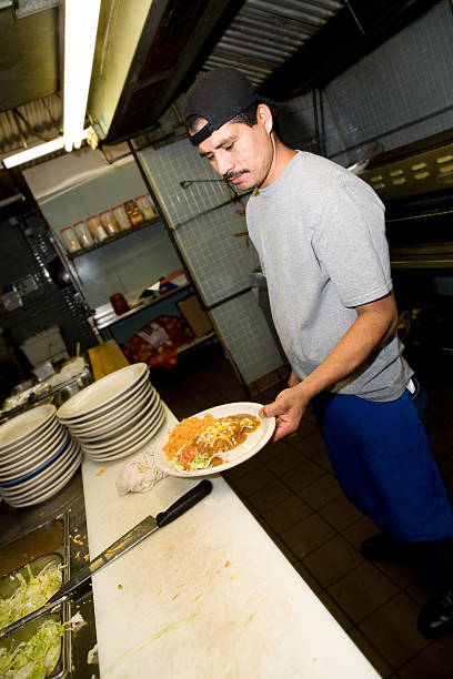 Mexican Restaurant Cook Holding a Plate of Tex-Mex Food Mexican Restaurant Cook Holding a Plate of Tex-Mex Food.See more from this series: mex mexican restaurant tex stock pictures, royalty-free photos & images