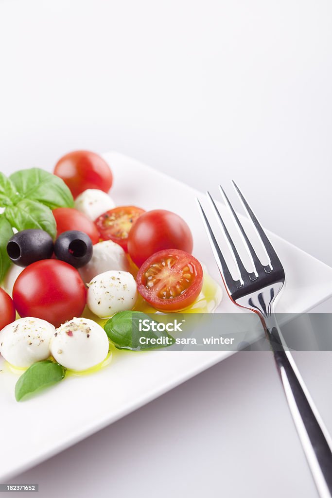 Salada Caprese frescas em uma mesa sob luz brilhante - Foto de stock de Alimentação Saudável royalty-free