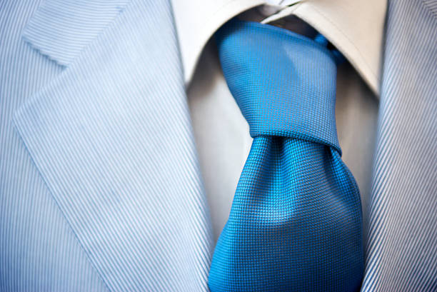 Man in smart suit adjusting tie on a wedding day