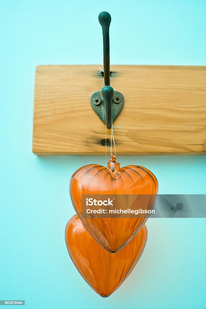 Valentine Hearts Two Glass decorative hearts hang from a wall coat hanger Broken Stock Photo