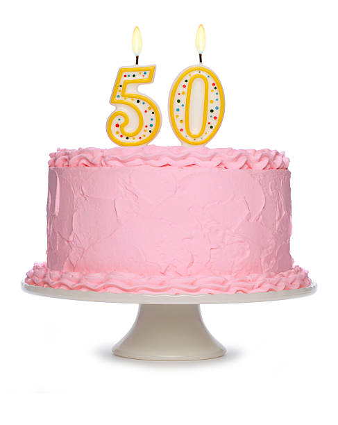 Birthday cake decorated with pink icing and candles stock photo