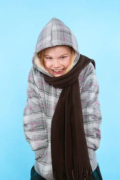 9 year old smiling girl shivering from the cold.similar image: