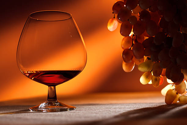 Cognac Glass of Cognac and grapes cognac brandy stock pictures, royalty-free photos & images