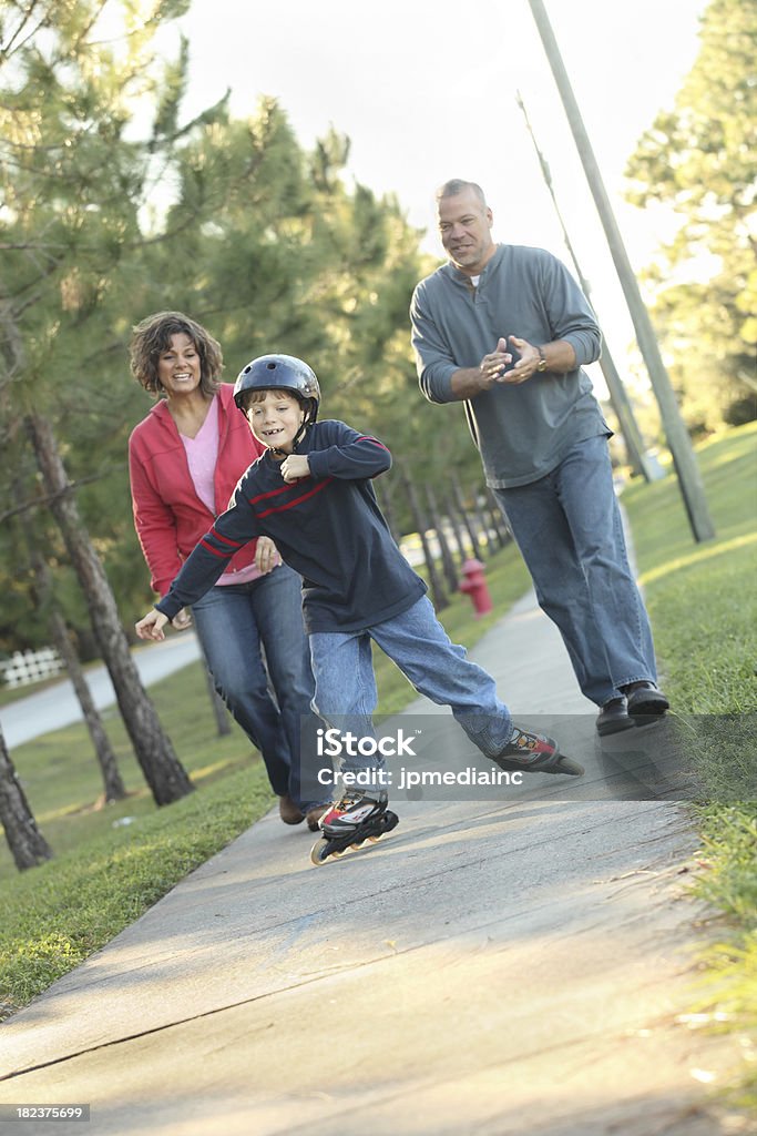 Son du roller avec les parents aide - Photo de Adulte libre de droits