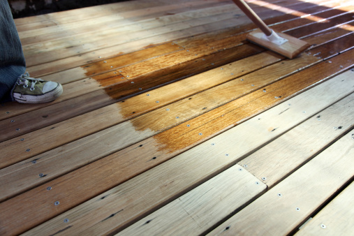 Oiling a recycled timber outdoors deck for protection against the elements