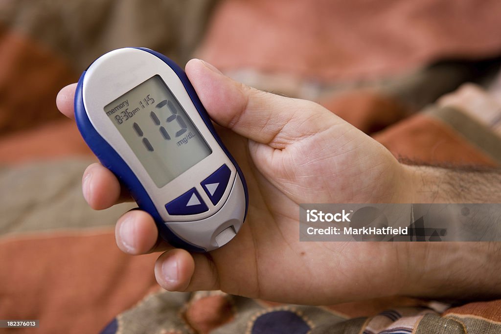 Hombre pruebas, su nivel de azúcar en sangre con un glucómetro - Foto de stock de Glucómetro libre de derechos