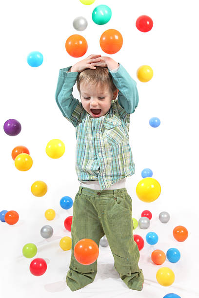 istock Happy little boy being rained on by colored balls 182376132