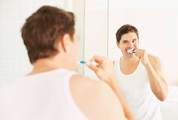 istock Mid adult man brushing teeth in the bathroom 182376454