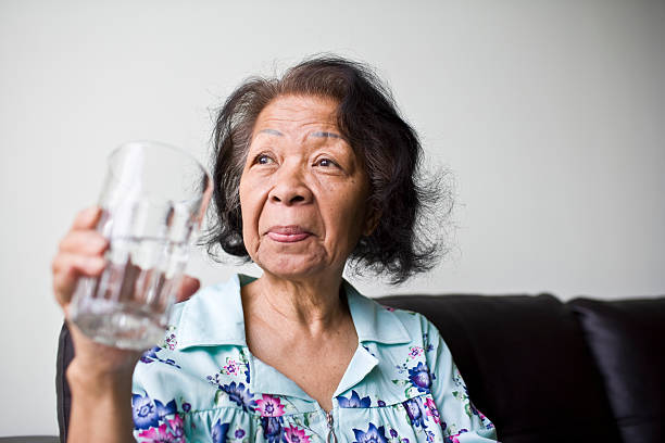 starszy kobieta wody pitnej - adult beverage zdjęcia i obrazy z banku zdjęć