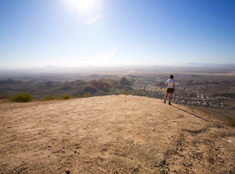 Hiker standing at the Gila Valley lookout on South Mountain Park, Phoenix, Arizona.