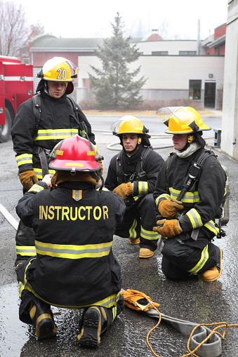 Firemen in training with fire hose and rope a foggy day.