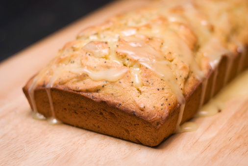A loaf of lemon poppyseed bread.  It has a lemon glaze on top of it.  The main focus is on the front right corner of the bread.Similar: