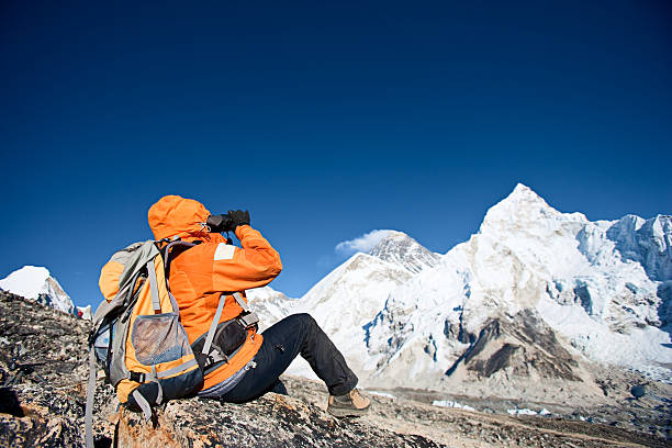 istock Woman looking through binoculars at Mount Everest 182379034
