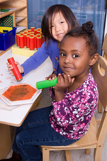 istock Little girls using stamps at school 182379669