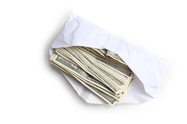 Envelope filled with stack of hundred dollar bills Envelope filled with stack of hundred dollar bills bribing stock pictures, royalty-free photos & images