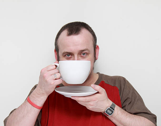 istock thirty year old man holds huge cup and saucer 182380204