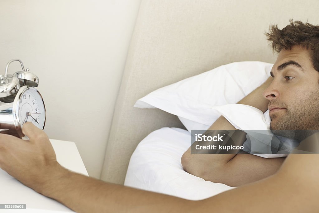 젊은 guy 침대 루킹 유클리드의 알람 시계 - 로열티 프리 20-24세 스톡 사진